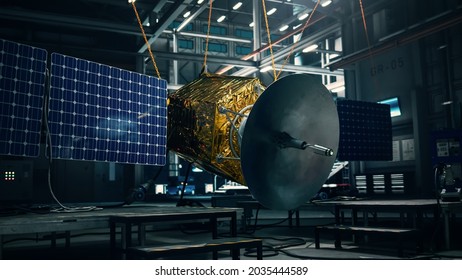 Satellite Under Construction In Dark Aerospace Technology Manufacturing Facility. Development Of Spacecraft For Space Exploration, Navigation, Communications, Internet Telecommunication, Observation.