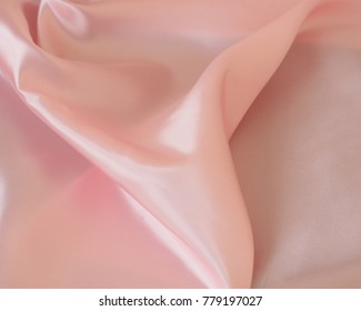 Satin pink fabric and the top view. Beautiful pleats on the fabric. Delicate peach shades. Iridescent Shine of fabric.