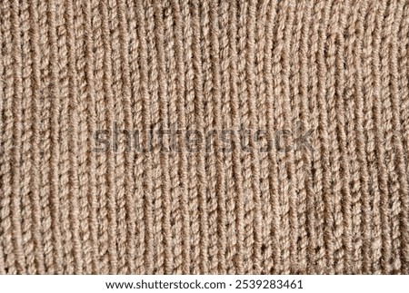 Satin stitch knitting pattern. Beige wool close-up. Warm thread for knitting clothes for winter.