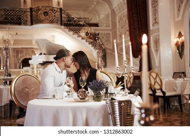 Satisfaction between these two lovers. Beautiful couple have romantic dinner in luxury restaurant at evening time.