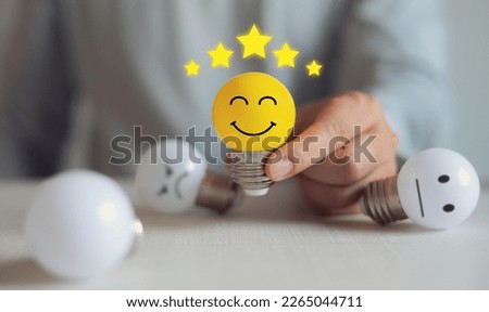 Satisfaction and customer service concept, businessman picks up yellow light bulb showing very satisfied mood