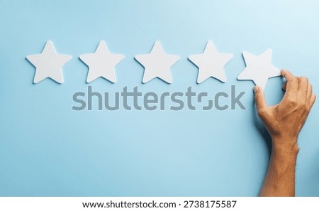 Satisfaction, paramount for customer feedback, shown by hand placing highest five star rating, reflecting positive service experience, client appreciation, and survey success.