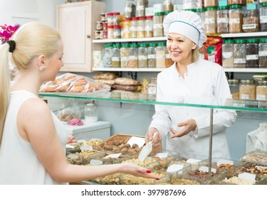 Satisfied American Mature Woman Buying Different Nuts In Local Supermarket