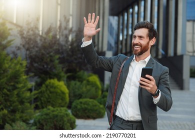 Satisfied Businessman in suit going home after long working day and waving bye to colleagues