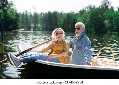 Satisfied couple. Couple of beaming elderly man and woman wearing sunglasses feeling satisfied after river trip - Powered by Shutterstock