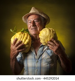 Satisfied Farmer Portrait With Two Giant Cedars Fruit Around The Neck.  Black And Yellow Background