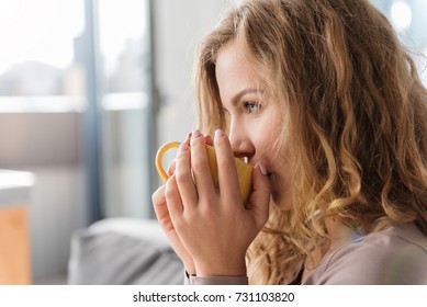 Satisfied Female Enjoying Cup Of Coffee