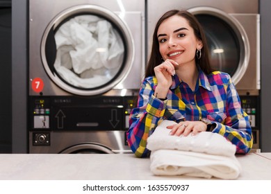 Satisfied laundry client against the background of dryers 