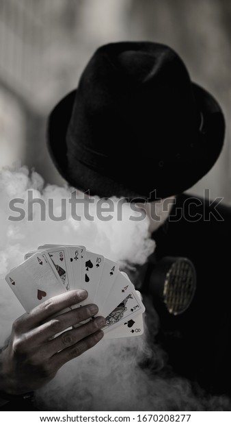 Satisfied male gambler shows royal flush in\
his hand. Dark color\
intensity.
