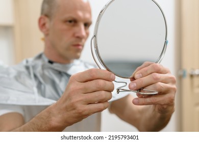 Satisfied Man Holding Mirror And Looking On Results Of His Self Haircut