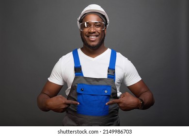Satisfied mechanic in a hard hat is very pleased with his new work uniform, showing off a large blue breast pocket on a jumpsuit. Roomy pocket on the new model of the uniform for the layout
