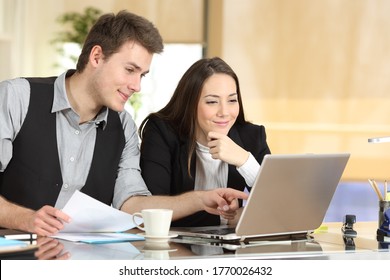 Zufriedene Büroangestellte prüfen Ihre Laptop-Online-Inhalte im Büro