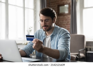 Satisfied shopper man using credit card with good term conditions, making purchase, payments on webstores, paying bills, invoice, fees, spending money, getting cashback