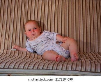 A Satisfied Well Fed Fat Baby Lies On The Couch With A Swing And Smiles Cheerfully