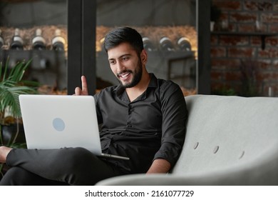 Satisfied Wine Shop Owner Looking At His Laptop Screen .