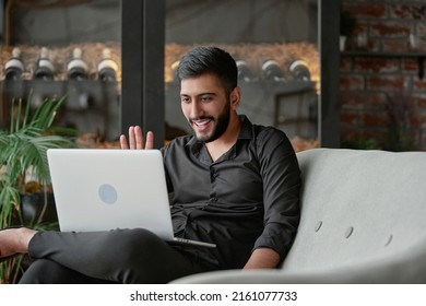 Satisfied Wine Shop Owner Looking At His Laptop Screen .