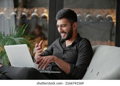 Satisfied Wine Shop Owner Looking At His Laptop Screen .