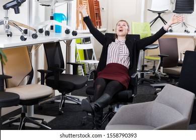 Satisfied Young Woman Sitting In Ergonomic Office Chair In Furniture Store Before Buying
