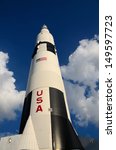 Saturn V rocket as sitting on the launch pad surround with clouds.