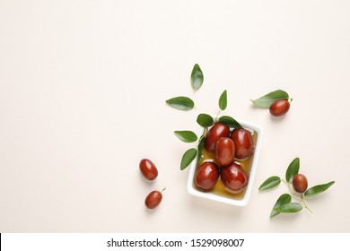 Sauce boat with jojoba oil and seeds on light background, flat lay. Space for text