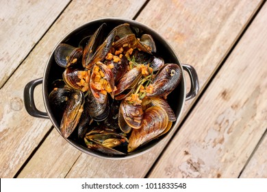 Saucepan of prepared mussels and vegetables. Top view of steamed mussels.