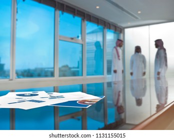 Saudi Arab Businessmen Talking In A Meeting Room, Focus On Ducuments On The Table