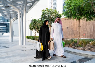 Saudi Arab Couple Shopping Happy Family Together Holding Bags Walking Wearing Traditional Clothes Enjoying Sale In Summer