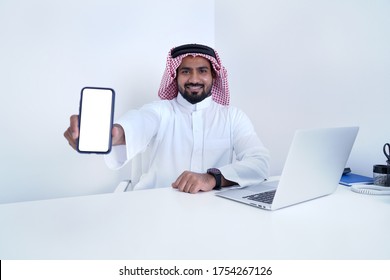 Saudi Arab Man Showing Phone Display With Some Message While Working On Laptop                