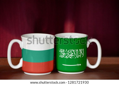Saudi Arabia and Bulgaria flag on two cups with blurry background