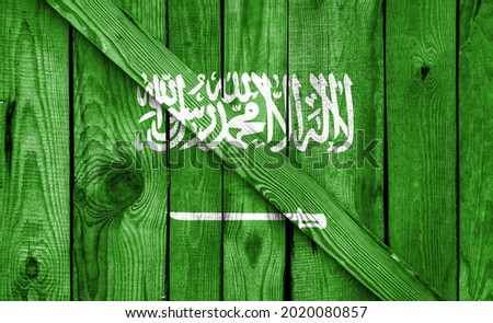 Saudi Arabia flag is depicted on a wooden background close-up