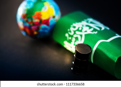 Saudi Arabia Flag And Oil Barrel On Green Grass Field