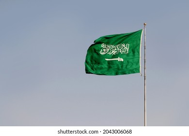 Saudi Arabian Flag waving with the wind featuring a sword and the islamic text called the Shahada or muslim creed