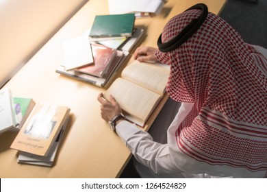 Saudi Arabian Man Reading A Book In The Library