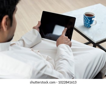 Saudi Arabian Man Using Tablet At Home Environment