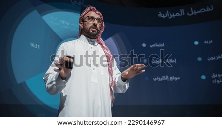 Saudi Businessman Making a Presentation on Stage During a Middle Eastern Business Conference. Entrepreneur in White Thobe Talking About Financial Growth, New Market Development, Marketing Strategy