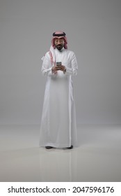 A saudi character holding the phone and looking to the phone on withe background