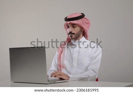 A saudi character sites at the desk using laptop with different positions on withe background