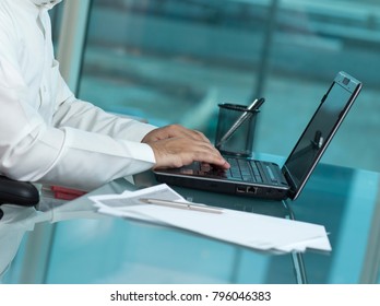 Saudi Man Hands Typing On Laptop At His Desk. Headless