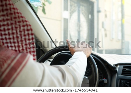 Saudi men waiting in his car.