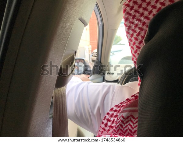 Saudi men waiting in his\
car.