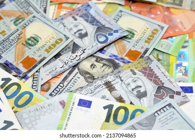 Saudi riyals money with American dollars bills and European euros banknotes, a pile of 200 and 500 Saudi Arabia riyals, 100 one hundred dollars and 100 one hundred euros exchange rate, selective focus