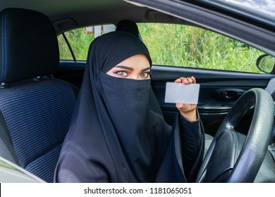 Saudi Woman Driving A Car And Showing A Blank Driving Licence For Graphic Montage. Muslim Woman Driver Concept