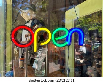 Saugatuck, Michigan, USA - July 18, 2022 Rainbow Themed Neon Open Sign Hanging In A Storefront Window. Store Showing Its Pride And Welcoming The Gay Community.