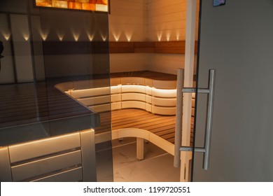 Sauna with open doors and luxury interior. Sauna with open doors and wooden seats with lights. Modern sauna interior. Sauna room with lights.
