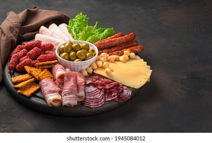 Sausage and cheese slicing on a round cutting board on a brown background. Side view with copy space. - Powered by Shutterstock