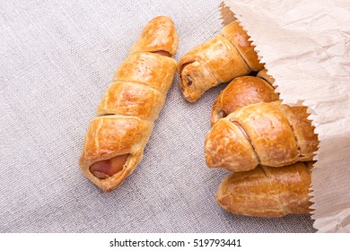 Sausage In The Dough In A Paper Bag On A Linen Napkin, Fast Food, Close Up