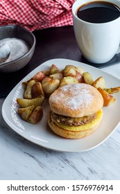 Sausage Egg And Cheese Breakfast Sandwich On An English Muffin With Home Fries And Coffee