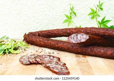 sausage on a wooden base and salad with spices