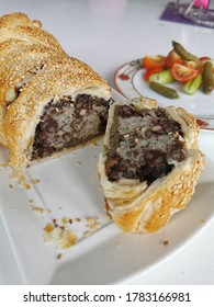 Sausage Plait With Black Pudding On A White Plate