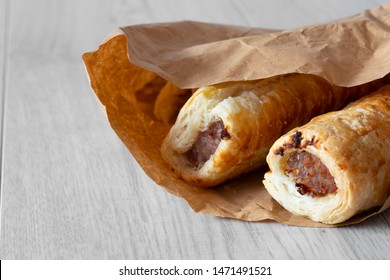 Sausage Rolls In A Brown Paper Bag, Environmentally Friendly Biodegradable Packaging, With A Grey Wood Background